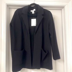 Black jacket with pockets. Does not have a button or zipper.